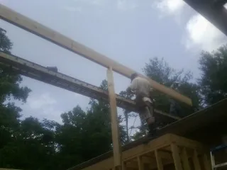 Carpenter setting a ridge beam over a new addition frame — Ice Dam Removal by Roofing Brothers in Naches