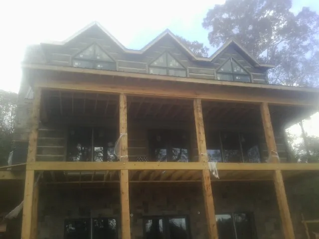 Dormers and porch framing on a large log home under construction — Roof Coating work by our crew in Naches